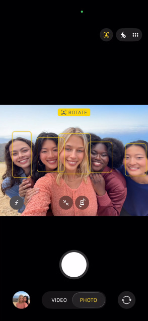 iPhone 17 Pro Vorderseite, das Display zeigt das Automatische Ausrichtung für Fotos Feature und wie eine Gruppe von Personen ein Selfie macht, während ihre Gesichter hervorgehoben sind